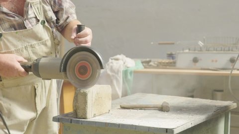 Man working with a manual cutting tool in his workshop