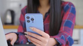 Girl using modern mobile phone. Young female browsing internet on blue smartphone device with triple camera. Person use new cellphone for entertainment and communication online