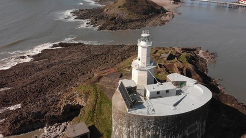 short aerial orbit view of mumbles lighthouse from the sea looking inland