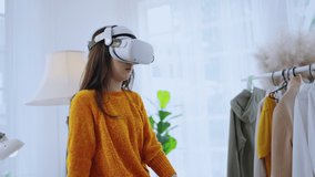 smart casual asian businesswoman attend online virtual meeting presentation new collections cloth fashion set to her worldwide client using virtual reality technology vr headset at home studio daytime