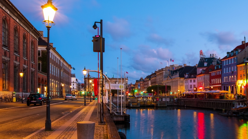 Copenhagen, Denmark. Morning view of the famous Nyhavn area in the center of Copenhagen, Denmark. Various boats moored with historical buildings and sunrise sky. Time-lapse, panning video