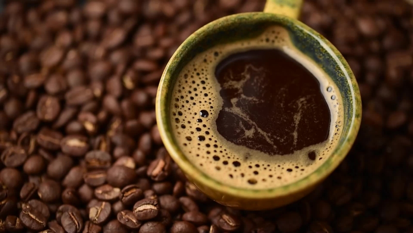 Close up of coffee cup.coffee beans.Falling drop into coffee cup,rotate coffee beans cups.pour the milk into the glass  | Shutterstock HD Video #1088253245