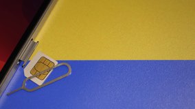 Closeup shot of the Ukrainian flag and a smartphone with a sim card. Communication during the war. Some companies provide free calls to Ukraine. Camera slowly zooming out. Text space.  - Powered by Shutterstock - Get 15% off with code: PIKWIZARD15