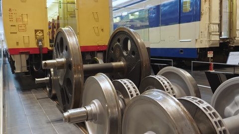 Nagoya.Japan-October 31.2019: Different train wheels displayed in the railway museum in Nagoya Japan. Wagons in the background. Engineering. Camera slowly tilting upwards.