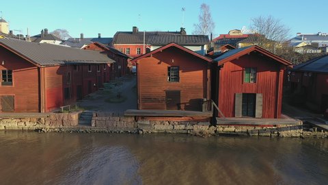 Porvoo.Finland-December 12.2020: Closer view of the old red wooden houses next to the river in Porvoo Finland with calm moving aerial shot in late autumn of the local architecture