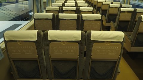 Nagoya.Japan-October 31.2019: Rows of seats inside a retro train wagon. Windows. Railway museum in Nagoya Japan. Beige and black interior with white headrests. Camera slowly moving upwards. 
