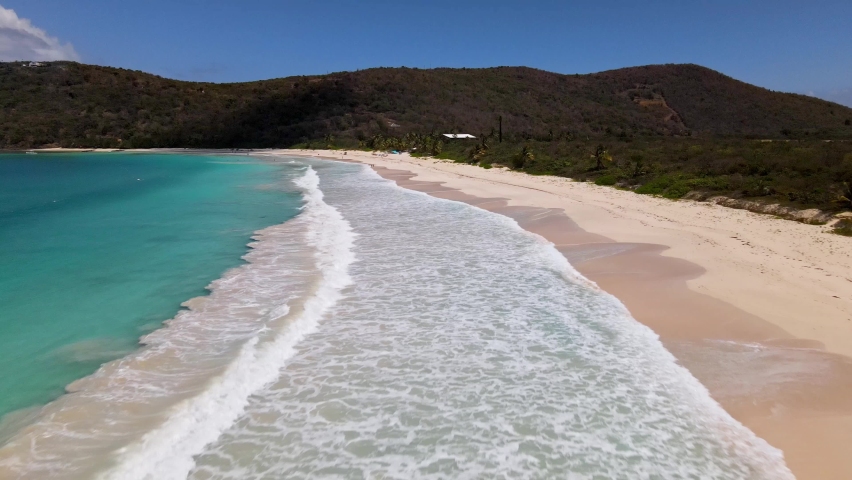DRONE BEACH TAKE OF WAVES BREAKING IN CRYSTAL CLEAR BLUE WATER