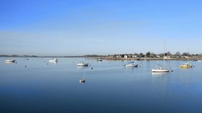 Yachts and Sailing boats in the calm and clear Emsworth estuary on a sunny and still early morning, Aerial video.