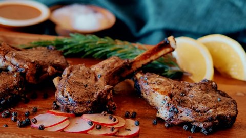 Grilled Lamb Chops with Rosemary and vegetables. Roasted Cutlets on Creative Restaurant Backdrop. Mutton Ribs with Spices and Sauce
