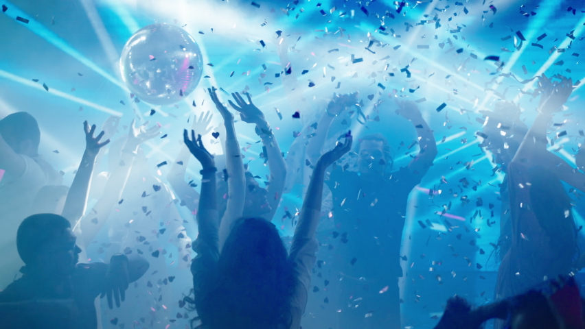 Amazing atmosphere in club. People enjoying dancing, falling confetti. Nightlife, modern music and entertainment concept. Royalty-Free Stock Footage #1088265427