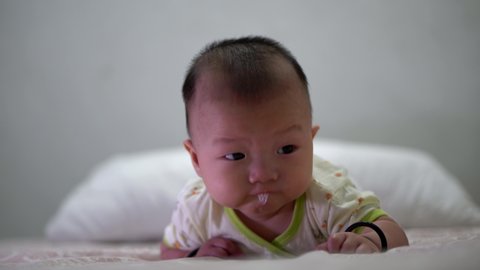 Asian baby drool while learn to roll over at bed