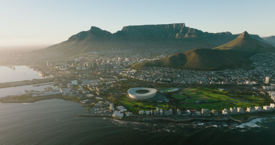 AFRICA,SOUTH AFRICA,CIRCA 2022.Spectacular high aerial view at sunrise of the Cape Town Stadium,Waterfront,City Centre,Table Mountain,Lion's Head,Signal Hill,Cape Town, South Africa