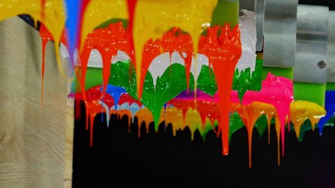 colorful plastisol ink stick on printer handle. 
tee shirt factory always use plastisol ink to print on tee shirt ang any fabric.
beautiful colors background. studio shot. dripping colorful paint.
