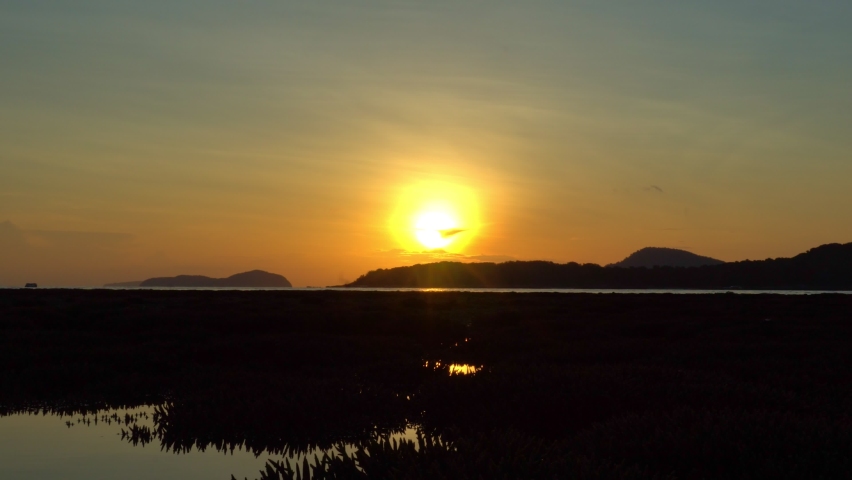 scenery yellow sunrise over the islands of the Andaman Sea.
 At Rawai Bay there is a complete staghorn coral field as a habitat for aquatic animals. 
During low tide coral fields above the water.
