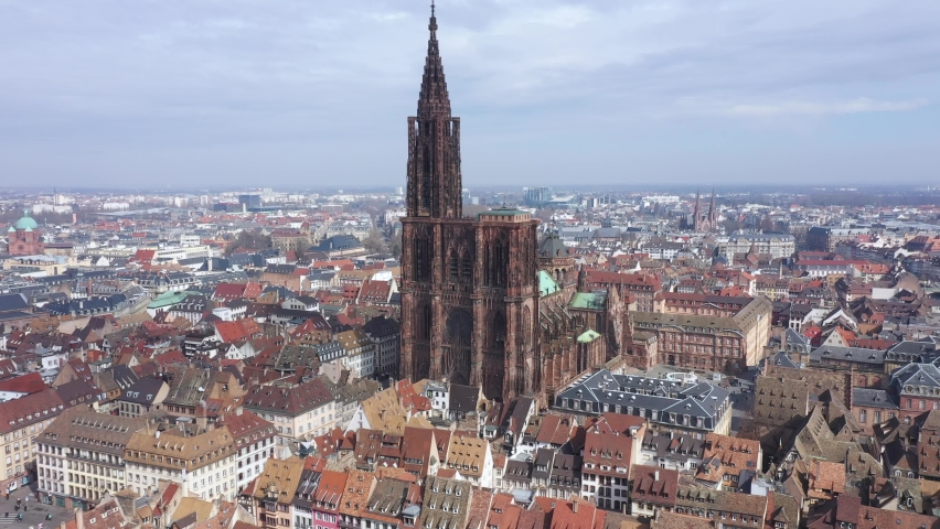 France, Strasbourg, European capital with Council of Europe and European Parliament. Drone aerial view of the famous red stone gothic Notre-Dame cathedral. German border on the back. | Shutterstock HD Video #1088278285