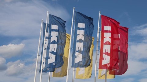 Belgrade, Serbia - August 06, 2021: Many Colorful Sweden Ikea Flags Flying at Sunny Summer Day Strong Wind.