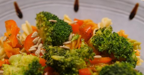 Fusilli Pasta With Sauteed Vegetables Served In A Bowl With Drops Of Balsamic Sauce. macro