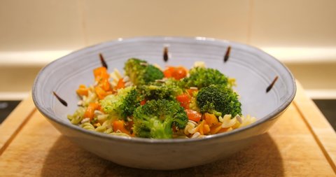 Balsamic Veggie Pasta In A Bowl With Balsamic Vinegar Drips. dolly shot