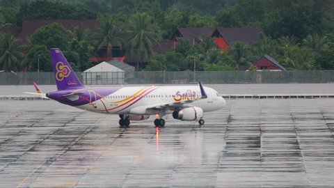 PHUKET, THAILAND - DECEMBER 02, 2016: Airbus 320, HS-TXN of Thai Smile taxiing after landing at Phuket International Airport. Thai Smile Thai regional airline. Airport airfield after heavy rain