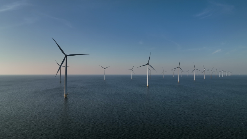 Wind turbines producing sustainable renewable energy in an offshore wind parkt. Drone point of view.