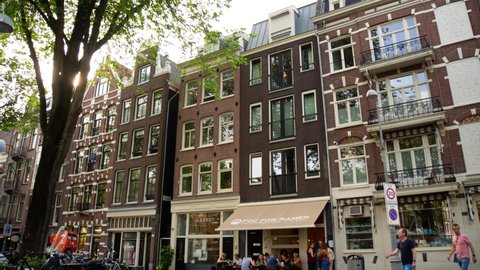 Amsterdam, Netherlands - 08-10-2019: Tourists in city center, historic old building architecture, hyperlapse, time lapse