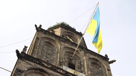 Groningen, The Netherlands - March 16 2022: Ukrainian flag wavering on the bell tower of the Martinikerk in Groningen to support the people of Ukraine.