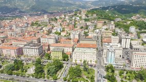 Inscription on video. La Spezia, Italy. Flight along the coast, Viale Italia street. View from above. Different colors letters appears behind small squares, Aerial View