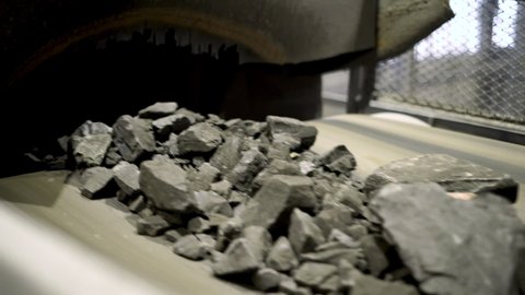 The movement of iron ore on the conveyor. Part of the technological process of mineral processing. Raw iron ore before processing. Raw material for metallurgy.