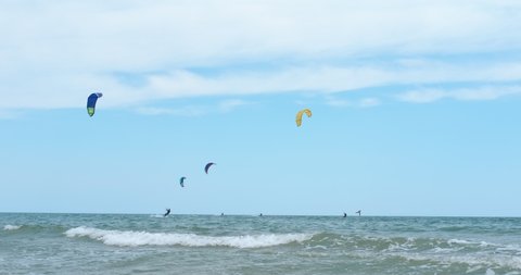 BULGARIA, KRANEVO JULY 2021. Extreme with kitesurf on waves. Athletes practice extreme kitesurfing in the clear ocean water in summer. Girl kitesurfing.