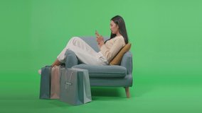 An Asian Shopping Woman With Shopping Bags Enjoy Using Mobile Phone Shopping Online While Sitting On Sofa In Front Of Green Screen
 - Powered by Shutterstock - Get 15% off with code: PIKWIZARD15