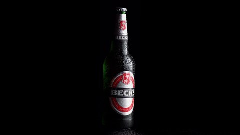 Berlin, Germany - March 15, 2022: German Beck’s labeled beer bottled rotating on a black background.