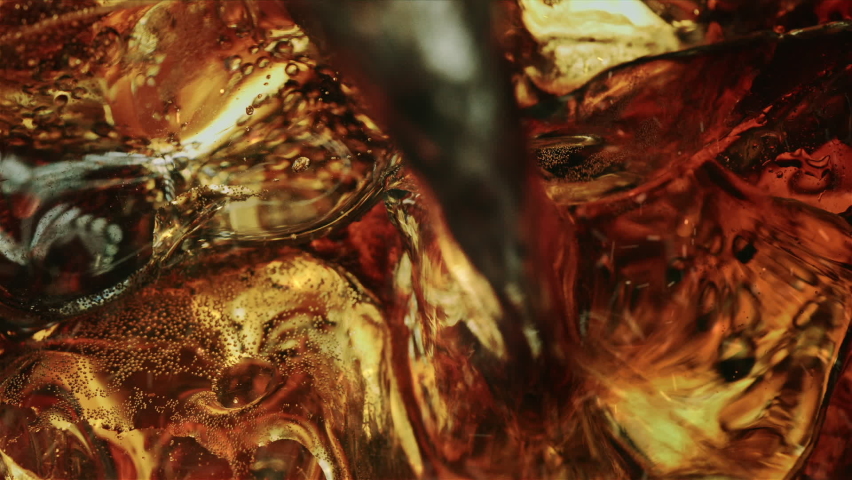 Pouring Fizzy Cola over Illuminated Ice Cubes and Whiskey in Macro and Slow Motion Royalty-Free Stock Footage #1088312257