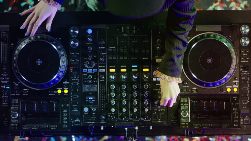 High angle view of professional mixing desk. DJ moving controllers. Nightlife, modern music and entertainment concept.