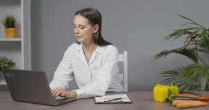 Professional nutritionist sitting at desk and giving advice on diet and healthy eating, webinar and online learning concept