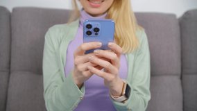 Cheerful young woman texting online with modern smartphone connected to 5g internet. White female typing message in mobile messenger app on modern cellphone. Person communicating online with cellphone