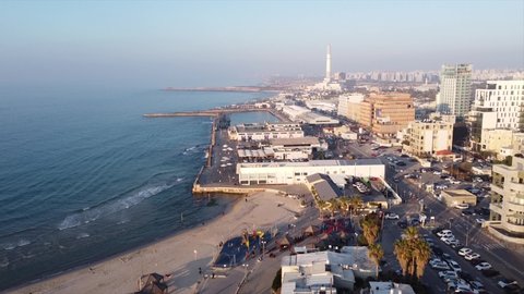 Tel Aviv, Israel - March 15, 2022: Aerial footage of Tel Aviv's Port with sea front hotels, beaches  and people at the beach.