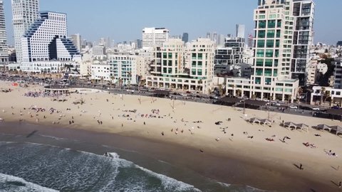 Tel Aviv, Israel - March 15, 2022: Aerial footage of Tel Aviv's coastline with sea front hotels, buildings and people at the beach.