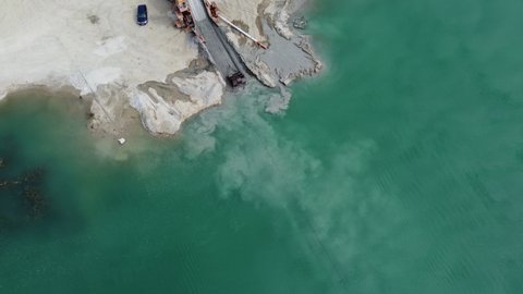 Sand mining with an excavator in the bed of the river Isar in Germany seen from a drone