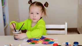 Little happy girl demonstrates her drawing of a heart card with puzzles for children suffering from autism. The child learns to give a helping hand, tolerance and respect for other people. Autism Day - Powered by Shutterstock - Get 15% off with code: PIKWIZARD15