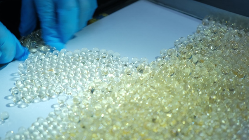 Close-up. An employee sorts gelatin tablets. Vitamins in capsules.