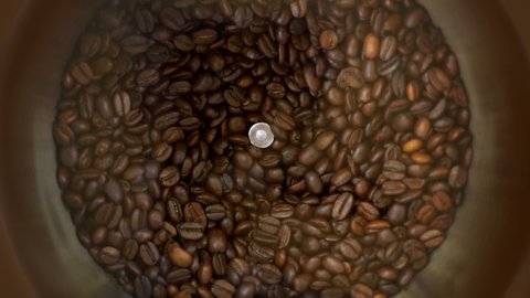 Slow motion close up shot of roasted coffee beans being ground into finer particles in a coffee grinder