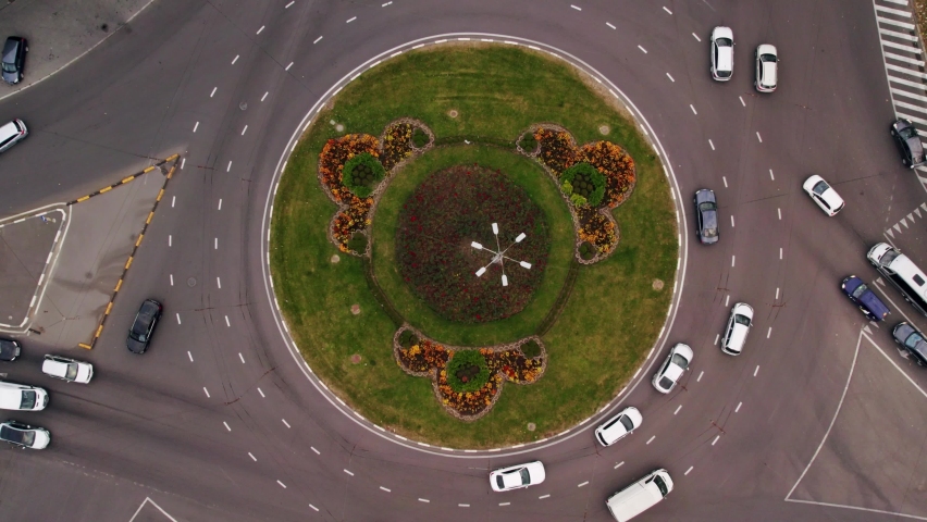 Traffic circle with a lot of cars. Top down aerial view on a circular intersection, life city on top, car traffic on road. Urban Traffic. Vehicles on a busy roundabout junction.  Royalty-Free Stock Footage #1088323987