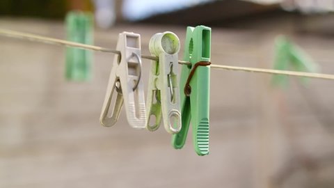 old pegs on a rope. One old retro clothespin wooden on a linen rope. Work on the house, washing, drying linen. Old Dirty Blue and Pink clothes peg on a rope Wire isolated on blurred background