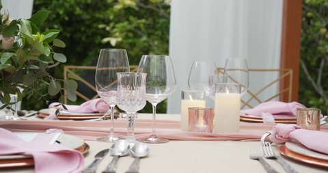 Dinner setting up festive table decorations wedding party reception. Pink color concept. Wedding chairs decoration ceremony outdoor park garden.