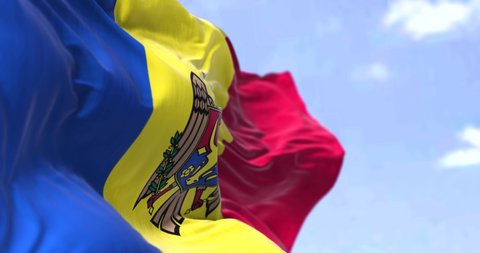 Detail of the national flag of Moldova waving in the wind on a clear day. Moldova is a sovereign state in Eastern Europe. Selective focus. Seamless looping in slow motion