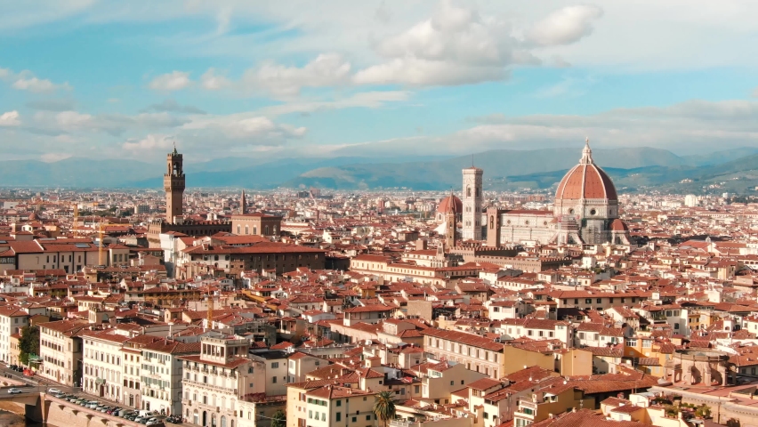 Establishing aerial drone view of Florence Cathedral, Cattedrale di Santa Maria del Fiore, Ponte Vecchio and The Arno River, Tuscany region of Italy Florence on a beautiful sunny day  Royalty-Free Stock Footage #1088327227