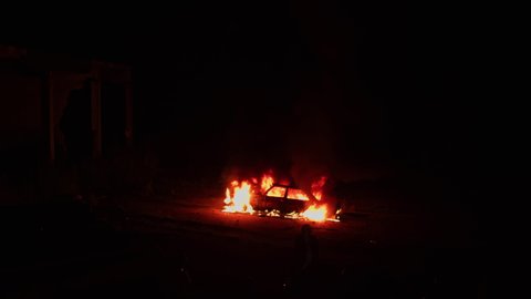 Dreadful scene of burning car. Automobile on fire. Transport explosion. Accident on roadside. Thriller movie filming area.