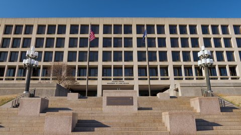 The United States Department of Labor Frances Perkins Building in Washington, D.C in the late afternoon. The camera tilts down from the blue sky to the building's facade seen from Constitution Avenue 