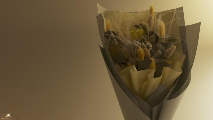 Console table with bouquet of flowers lit by a table lamp in the living room, apartment decoration background. High quality 4k footage