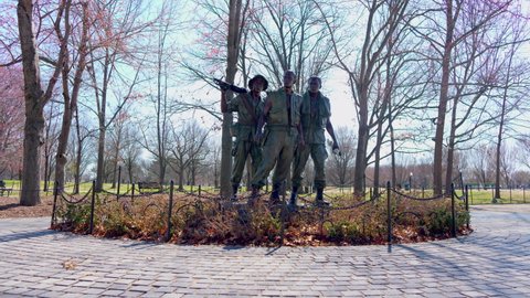 Washington, DC - USA - March 11 2022: The 'Three Soldiers' statue at the Vietnam Veteran's Memorial on the National Mall on a late winter day. The camera tilts up to reveal the statue..